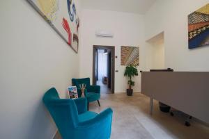 Bespoke Roma Suites في روما: غرفة معيشة مع كراسي زرقاء وبيانو