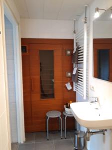 uma casa de banho com um lavatório e uma porta de madeira em B&B Stripsein em Wijnjewoude