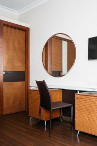 Habitación con silla y espejo. en Hotel Astoria en Barcelona