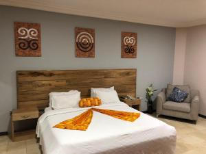 a bedroom with a large white bed and a chair at Central Hotel - OSU in Accra
