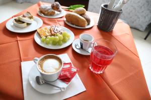 - une table avec des assiettes de nourriture et une tasse de café dans l'établissement Albergo Cantiani, à Ancône