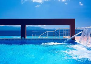a swimming pool with a water fountain on top of a building at Michelangelo Resort & Spa in Agios Fokas