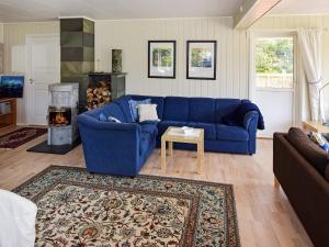 a blue couch in a living room with a fireplace at 4 star holiday home in Hennes in Hennes