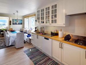 a kitchen with white cabinets and a dining room at 4 star holiday home in Hennes in Hennes