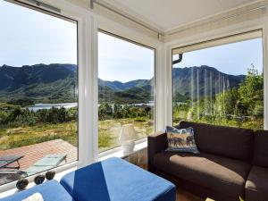 a living room with a couch and large windows at 4 star holiday home in Hennes in Hennes
