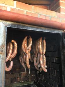 a bunch of sausages hanging from a brick fireplace at Hotel Sirákov in Liptál