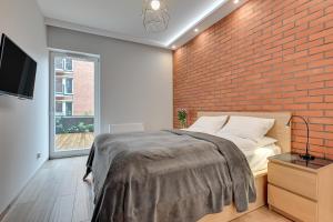 a bedroom with a brick wall and a bed at Central Apartment - free private parking in Gdańsk
