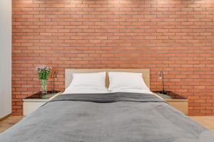 a bedroom with a brick wall and a bed at Central Apartment - free private parking in Gdańsk +14 photos