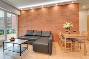 a living room with a couch and a brick wall at Central Apartment - free private parking in Gdańsk