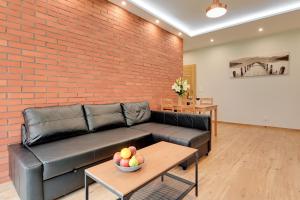 a living room with a couch and a brick wall at Central Apartment - free private parking in Gdańsk