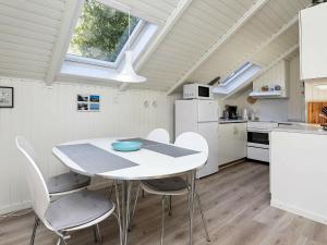 a kitchen and dining room with a table and chairs at 6 person holiday home in L s in Læsø