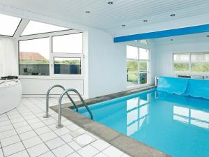 a bathroom with a swimming pool and a tub and a toilet at Four-Bedroom Holiday home in Løkken 28 in Lønstrup