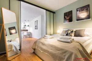 sypialnia z dużym łóżkiem i lustrem w obiekcie Apartments Nearto Old Town Vermelo w Krakowie