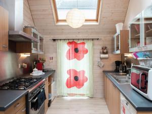 uma cozinha com uma janela com flores vermelhas em Beautiful Apartment in Spa Belgium with Jacuzzi em Spa
