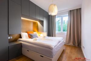 sypialnia z dużym łóżkiem i oknem w obiekcie Apartments Nearto Old Town Vermelo w Krakowie
