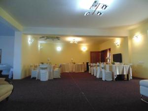 una sala banchetti con tavoli bianchi e sedie bianche di Pensiunea Casa Benko a Bacău