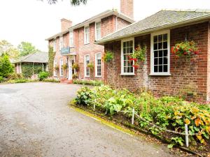 una casa de ladrillo con flores delante en The Gables Hotel en Gretna Green