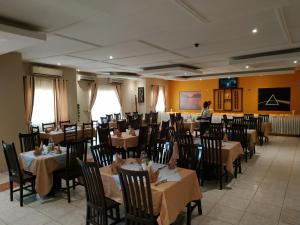 a dining room with tables and chairs and a woman in the background at Quality Hotel Juba in Juba