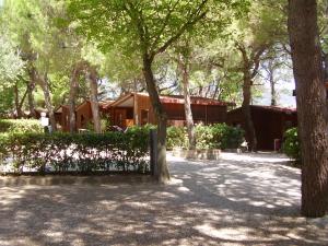 a fence in front of a house with trees at Camping Village Riviera in Numana