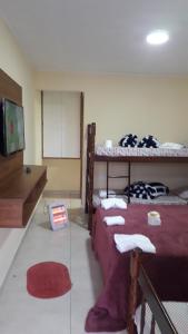 a room with two bunk beds and a flat screen tv at Suites Bella vista in Campos do Jordão