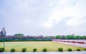 un campo de béisbol con césped verde y luces en The Raj Hotel and Resort en Jaipur