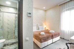a bedroom with a bed and a shower and a bathroom at Hotel Aivani Old Tbilisi in Tbilisi City +98 photos