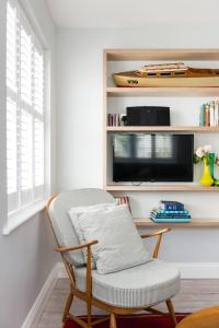 a living room with a chair and a tv at Seahorse Cottage in Aldeburgh