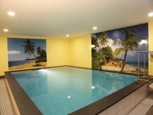 a swimming pool with a mural of the beach at Gäste und Ferienhof Maas in Dülmen