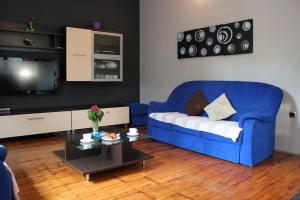 Sala de estar con sofá azul y mesa de centro en Roses Apartment en Lukoran