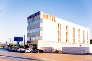 a hotel with cars parked in a parking lot at Bougainville Barreiras in Barreiras