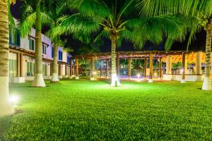une cour avec des palmiers en face d'un bâtiment dans l'établissement EXCLUSIVA VILLA EN LA ZONA HOTELERA DE IXTAPA_ZIHUATANEJO, à Ixtapa