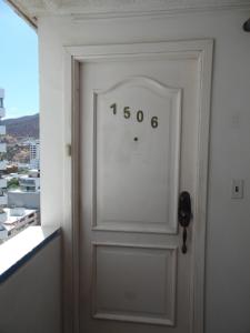 a door with a clock on it next to a window at Karey 1506 Rodadero in Gaira