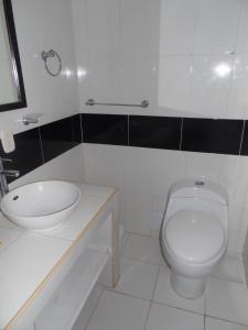 a white bathroom with a sink and a toilet at Karey 1506 Rodadero in Gaira