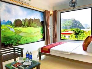 a bedroom with a large painting of a golf course at Trang An Mountain View Homestay in Ninh Binh