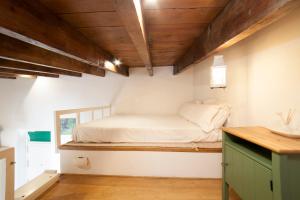 um pequeno quarto com uma cama na parede em AlohaMundi Castilla II em Sevilha