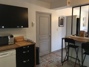 a kitchen with a counter and a table with a microwave at LES VILLAS TAGARINES - Villa Du Pin in Étables