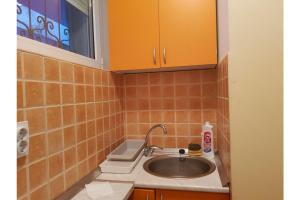 uma casa de banho com um lavatório e azulejos laranja em Bella Centre Apartment em Belgrado
