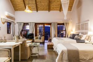 1 dormitorio con 2 camas y sala de estar en Karoo View Cottages, en Prince Albert
