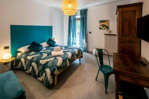a bedroom with a bed with a blue wall at Bed and Breakfast MADERA in Guarene