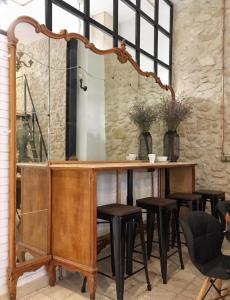 a bar with black stools and a mirror at Hostel Numero Trece in Alicante