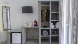 a room with a closet with a table and a shelf at Coralli Seaside Resort in Livadakia