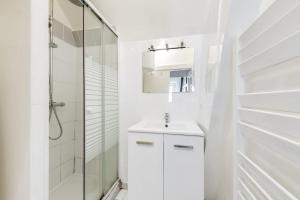 y baño blanco con lavabo y ducha. en Unit 015 Notre Dame (Ursins n°2) en París