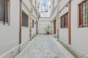 un callejón vacío entre edificios con una maceta en Unit 015 Notre Dame (Ursins n°2) en París