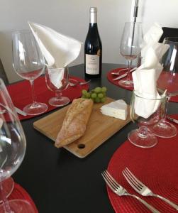 una mesa con copas de vino y una tabla de cortar con queso y uvas en French Riviera Condo 4 Rent in Marina Baie des Anges en Villeneuve-Loubet