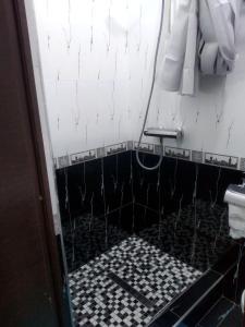 a bathroom with a black and white tiled floor at Samia House Room on Furkat 8 in Tashkent
