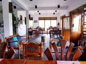a room with chairs and tables and a person sitting on a chair at Lakshmis Hotel Ella in Ella