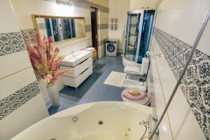 uma casa de banho com uma banheira, 2 lavatórios e um espelho. em Saban Deluxe em Lviv