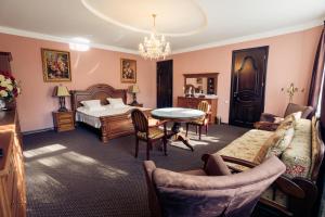um quarto com uma cama, uma mesa e cadeiras em Saban Deluxe em Lviv