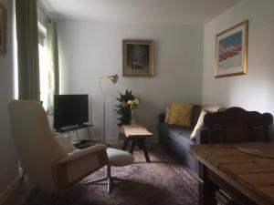 a living room with a couch and a tv at Lovely Apartment, Vuorimiehenkatu 31 in Helsinki