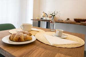 a table with two plates of pastries and two cups at Bed and Breakfast MADERA in Guarene